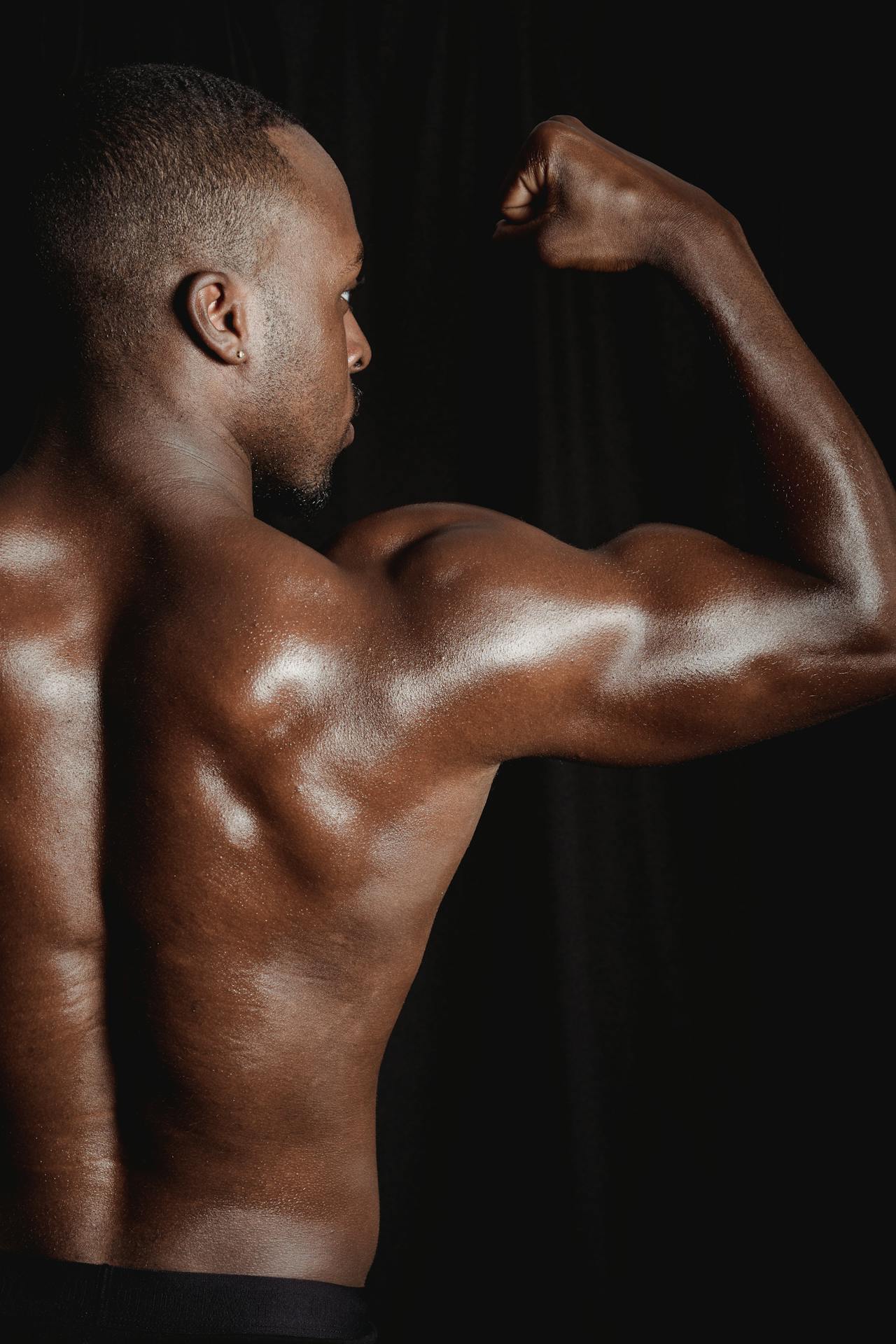 Massieve bodybuilder flext zijn biceps in de gym